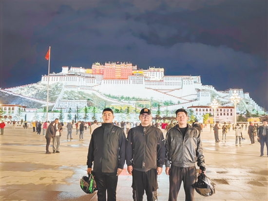余鸿威(左一)与摩友在拉萨布达拉宫前合影留念。